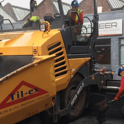 Til-Ex surfacing team laying asphalt with a branded paving machine