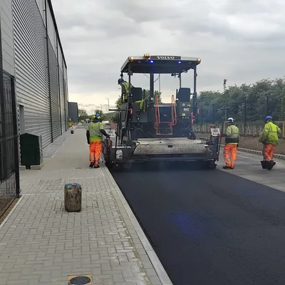 Surfacing team working behind a paver on an industrial access road