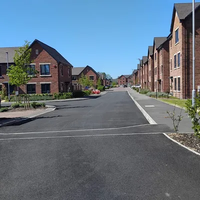 Residential development road with newly laid asphalt and brick homes
