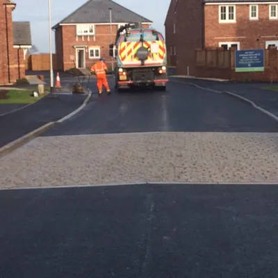Residential estate road surfacing work with a vehicle on site